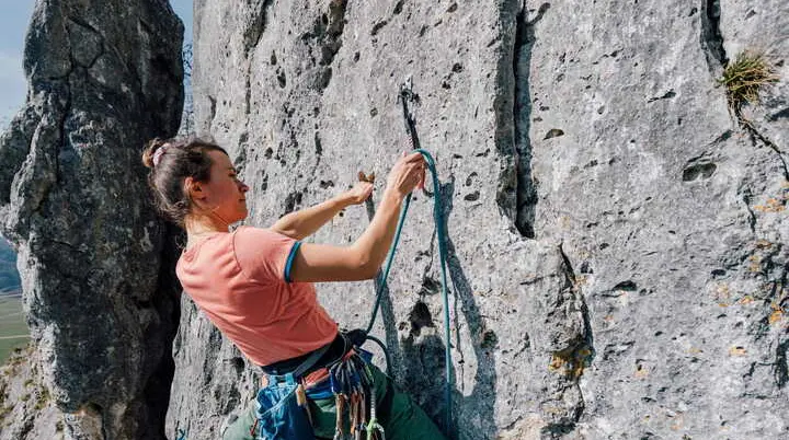 Eine Frau klettert an einem Fels | © Julian Rohn