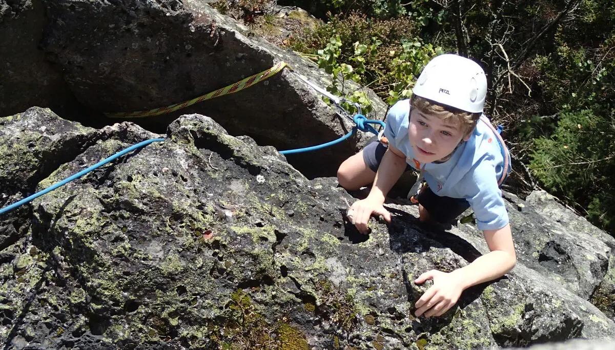 Ein Junge klettert an einer Felswand | © Christine Eyle