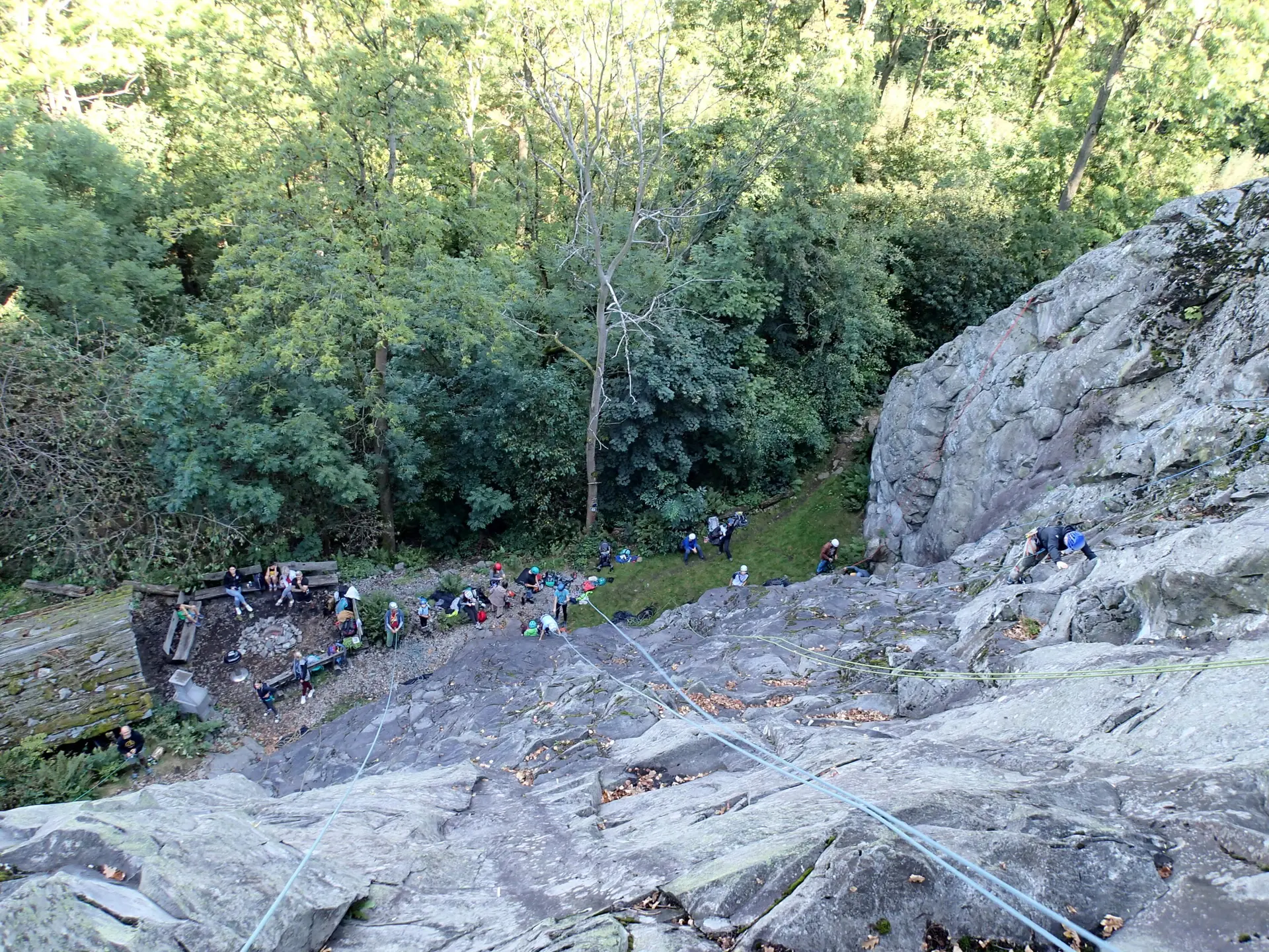 Lange Seile hängen eine Felswand herunter, unten stehen Kletterer | © Christine Eyle