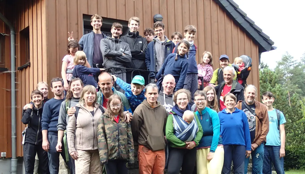 Etwa 30 Menschen stehen vor einer Hütte | © Christine Eyle