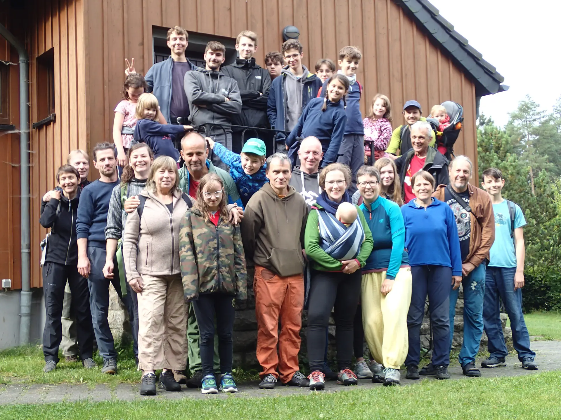 Etwa 30 Menschen stehen vor einer Hütte | © Christine Eyle