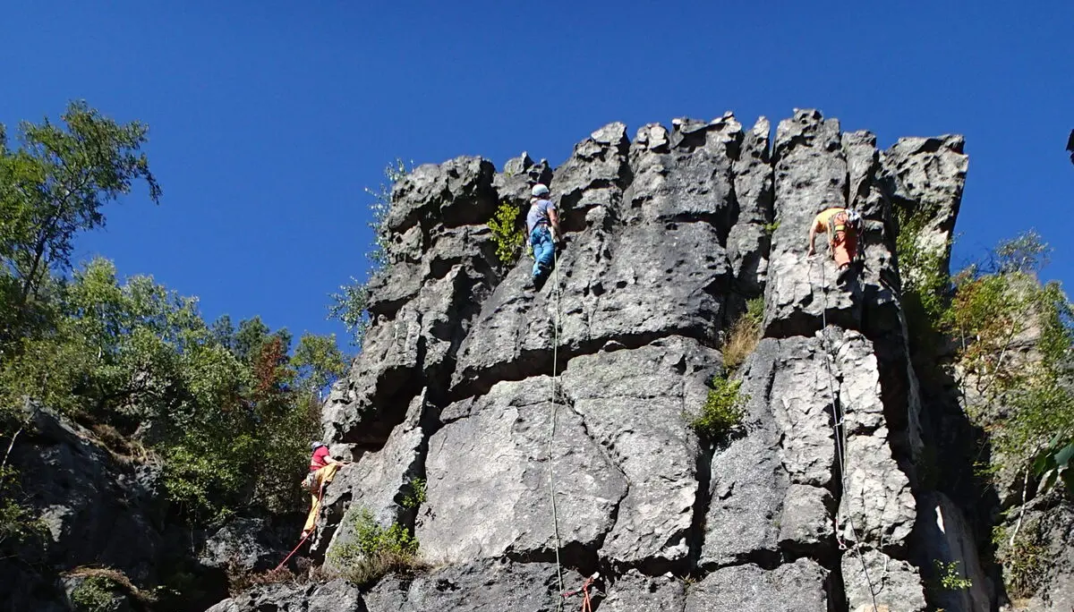 Ein großer Fels, an dem zwei Kletterer mit Seil klettern | © Christine Eyle