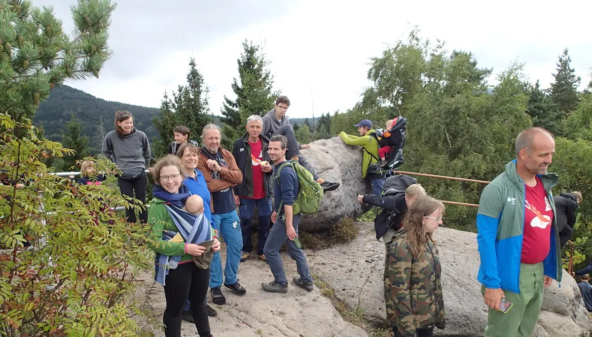 Eine Gruppe Wanderer steht auf einem Fels, im Hintergrund sind Hügel | © Christine Eyle